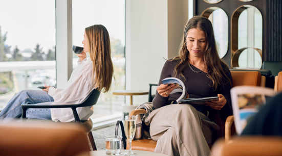 2 women sitting in airport lounge