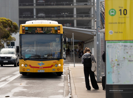 An image of some waiting at the Adelaide Airport bus stop as a bus is coming