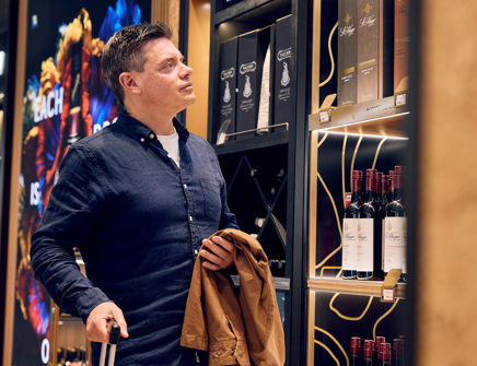 Man looks at bottles of alcohol
