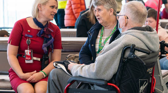 Adelaide Airport Staff talking to man while he is reading a guide