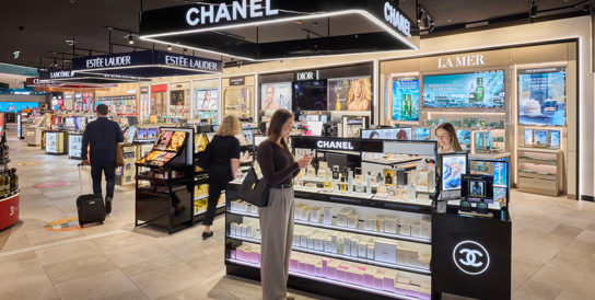 2 people walking past shops in Adelaide airport