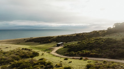 Small holiday stay on green rolling hills overlooking the ocean and South Australia's Kangaroo Island