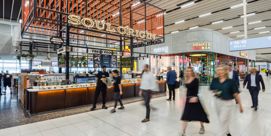 Two people walking through airport terminal 