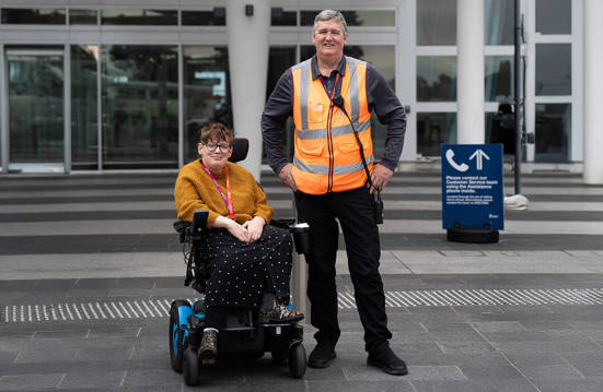 Adelaide Airport staff member outside the airport with a person in a wheelchair