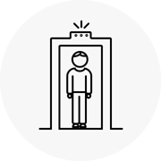 Icon of a person moving through and airport security scanner.