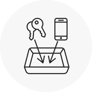 Icon of keys and a mobile phone going in a security tray
